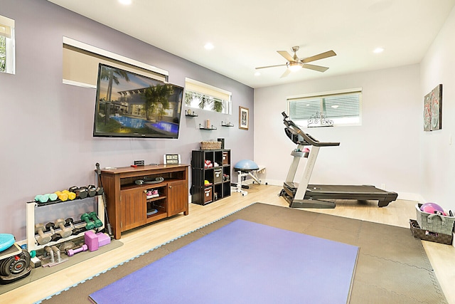 exercise area with ceiling fan and light hardwood / wood-style flooring