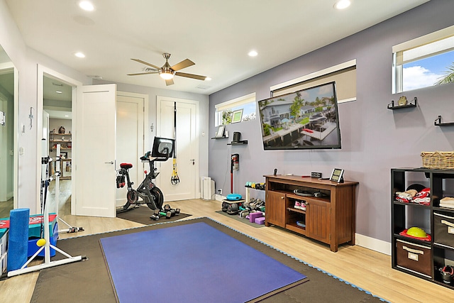 exercise area with ceiling fan and light hardwood / wood-style flooring