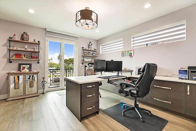 home office with light hardwood / wood-style floors and an inviting chandelier