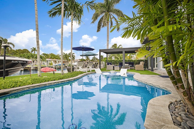 view of swimming pool featuring a water view and a patio area