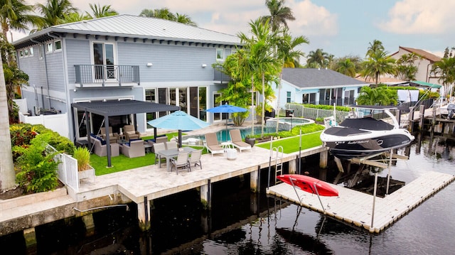 rear view of house with a patio, a water view, and a balcony