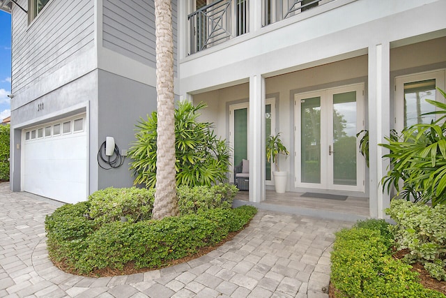 doorway to property with french doors, a balcony, and a garage