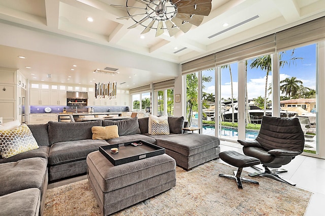 tiled living room featuring beam ceiling, coffered ceiling, and a notable chandelier