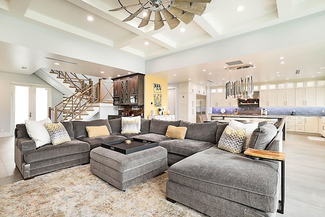 living room featuring beam ceiling, a towering ceiling, and coffered ceiling