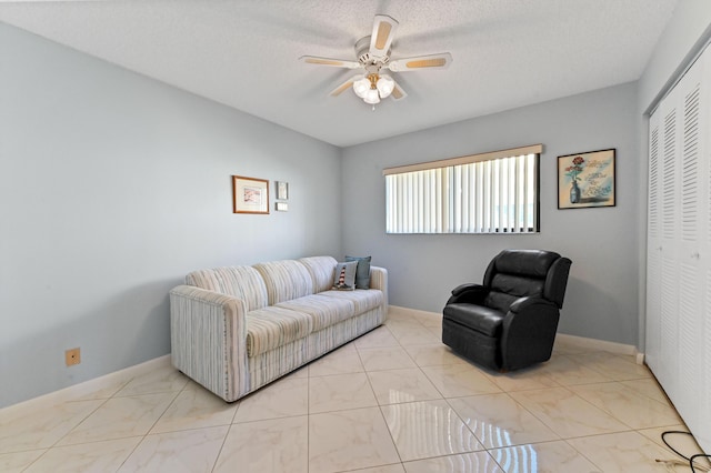 living room with ceiling fan and a textured ceiling