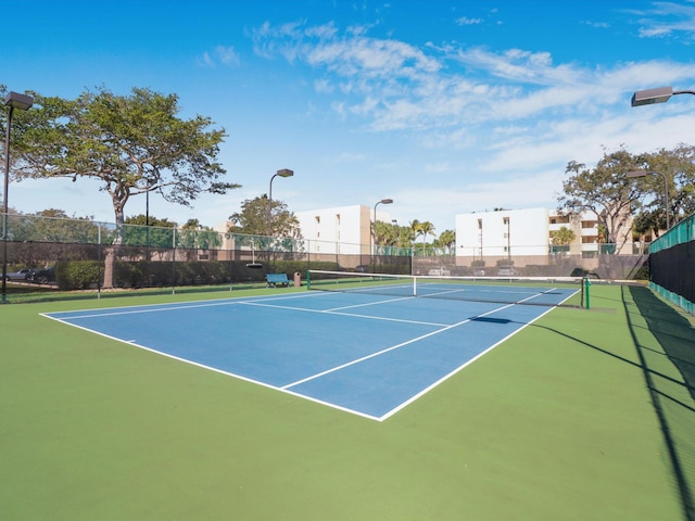 view of tennis court featuring basketball hoop