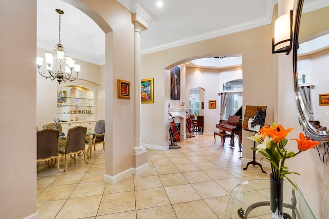 entrance foyer with a notable chandelier, ornamental molding, and light tile patterned floors