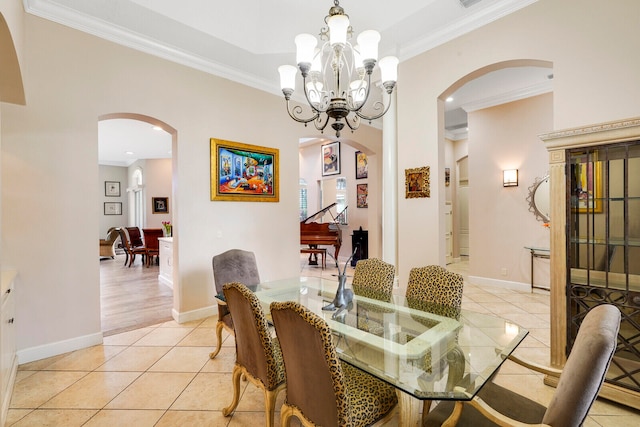 dining room with ornamental molding, light tile patterned floors, and an inviting chandelier