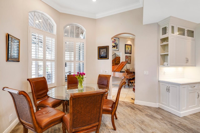 dining space with crown molding and light hardwood / wood-style floors