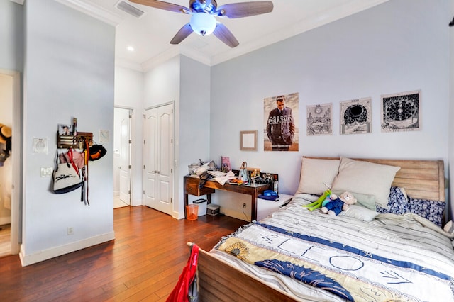 bedroom featuring dark hardwood / wood-style flooring, ceiling fan, and ornamental molding