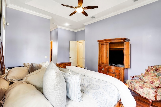 bedroom featuring a raised ceiling, ceiling fan, crown molding, and wood-type flooring