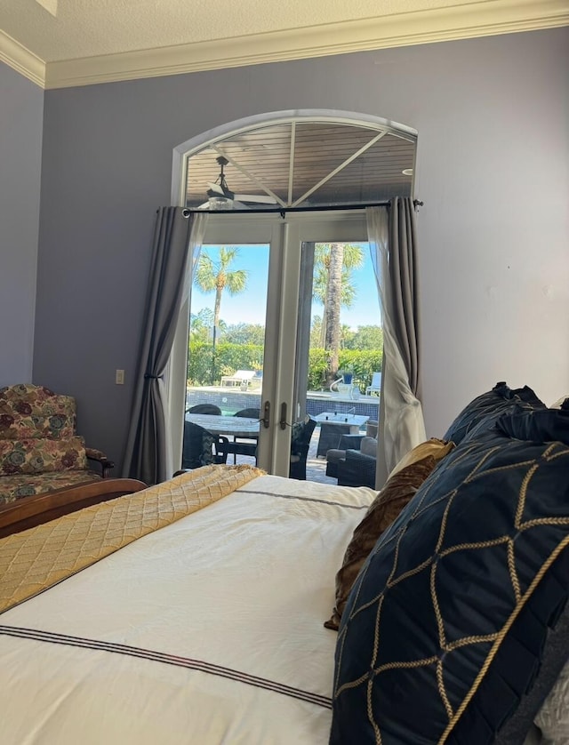 bedroom with a textured ceiling, crown molding, access to outside, and french doors