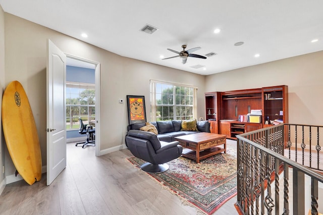 living room featuring light wood-type flooring and ceiling fan