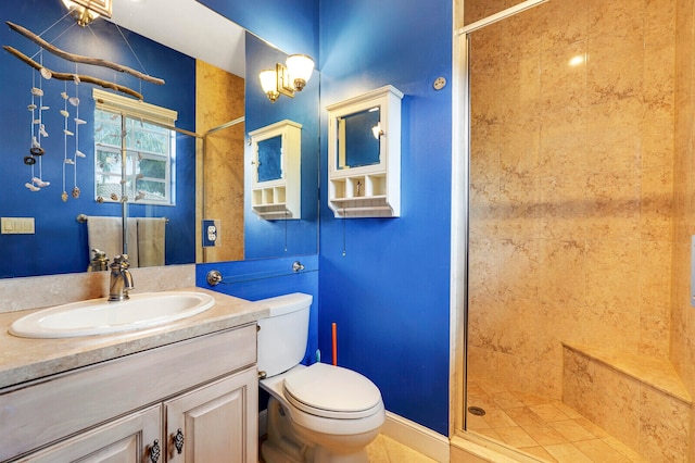 bathroom featuring tile patterned floors, a shower with door, vanity, and toilet