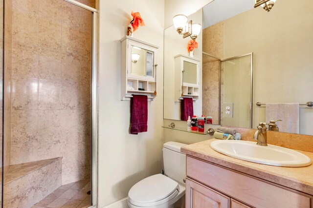 bathroom featuring vanity, toilet, and a shower with shower door