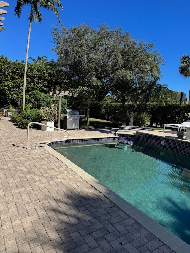 view of swimming pool with a pergola, a patio area, and grilling area