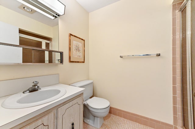 bathroom with tile patterned floors, vanity, an enclosed shower, and toilet