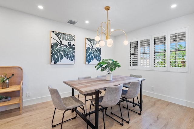 dining space featuring a notable chandelier and light hardwood / wood-style floors