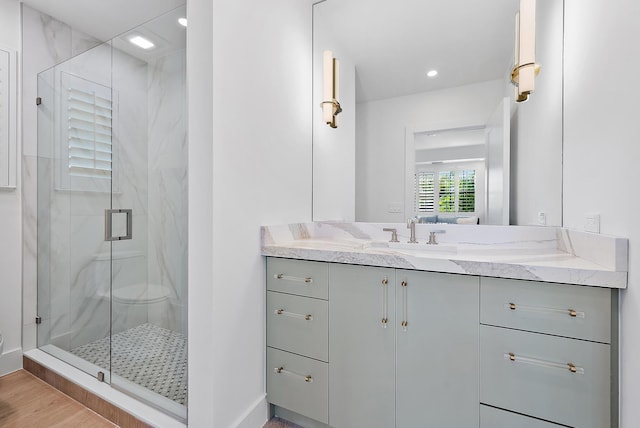 bathroom featuring vanity, wood-type flooring, and walk in shower