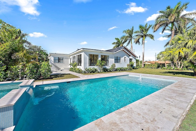 view of swimming pool featuring pool water feature and a yard