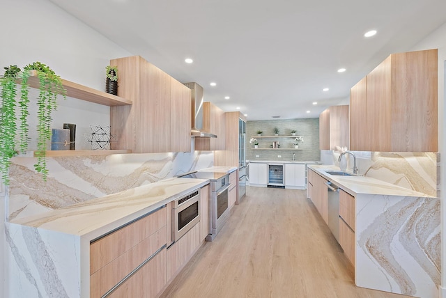 kitchen featuring light brown cabinetry, light hardwood / wood-style flooring, beverage cooler, and sink