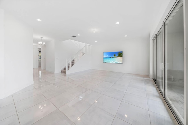 unfurnished living room featuring an inviting chandelier and light tile patterned flooring