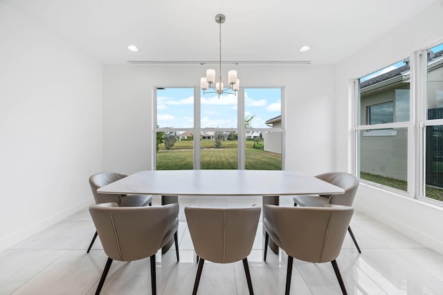 dining area featuring light tile patterned flooring, a wealth of natural light, and a chandelier