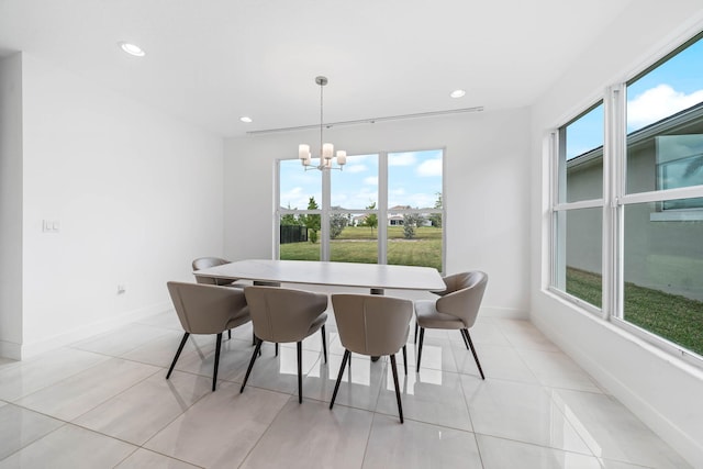 dining area with a chandelier, plenty of natural light, and light tile patterned flooring