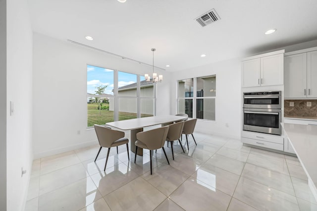 tiled dining space featuring a notable chandelier