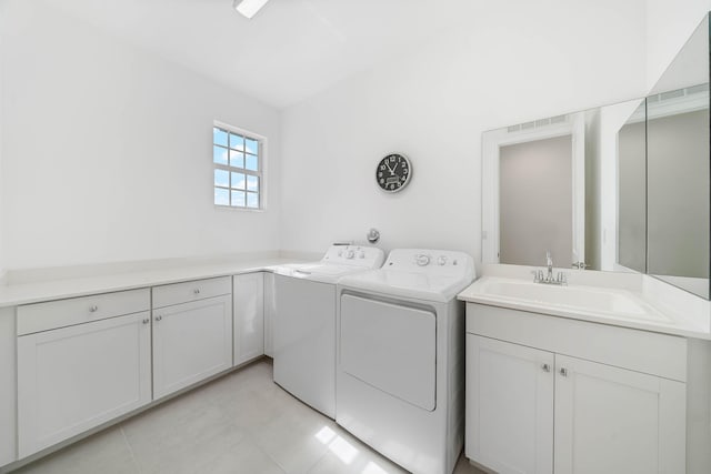 laundry room with cabinets, washing machine and dryer, and sink