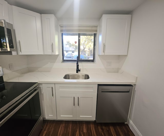 kitchen featuring white cabinetry, sink, stainless steel appliances, and light stone counters