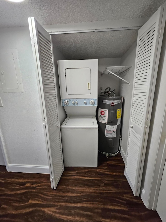 laundry room with a textured ceiling, dark wood-type flooring, water heater, stacked washer and dryer, and electric panel