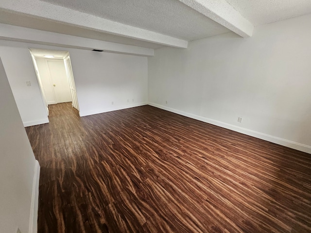 unfurnished room with a textured ceiling, beamed ceiling, and dark hardwood / wood-style floors