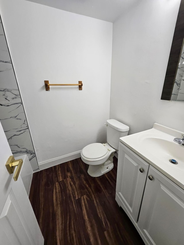 bathroom with wood-type flooring, vanity, toilet, and walk in shower