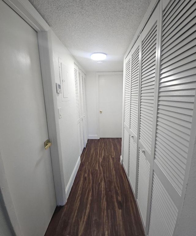 hallway featuring dark hardwood / wood-style flooring and a textured ceiling