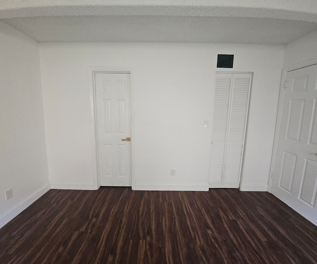 unfurnished room featuring dark hardwood / wood-style floors and a textured ceiling