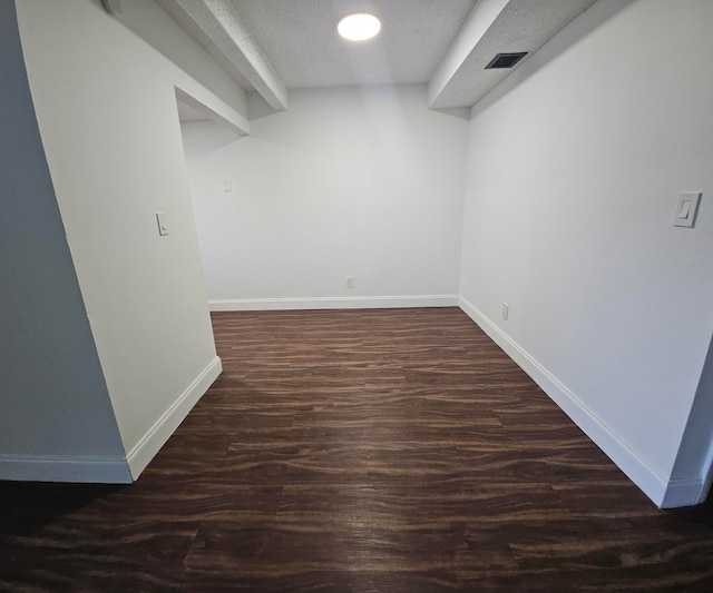 interior space featuring a textured ceiling and dark hardwood / wood-style floors