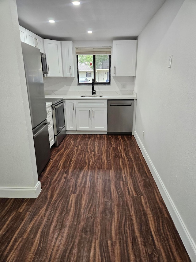 kitchen featuring white cabinetry, sink, stainless steel appliances, and dark hardwood / wood-style floors