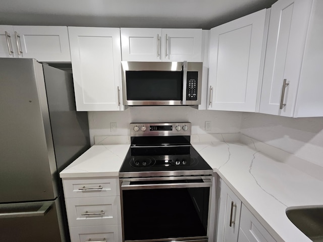 kitchen with white cabinets, light stone countertops, and appliances with stainless steel finishes