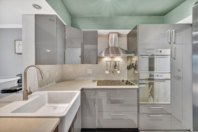 kitchen featuring backsplash, wall chimney exhaust hood, double oven, electric stovetop, and sink