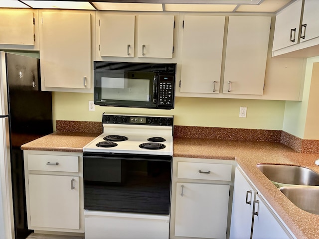 kitchen with white range with electric cooktop, stainless steel fridge, and white cabinets