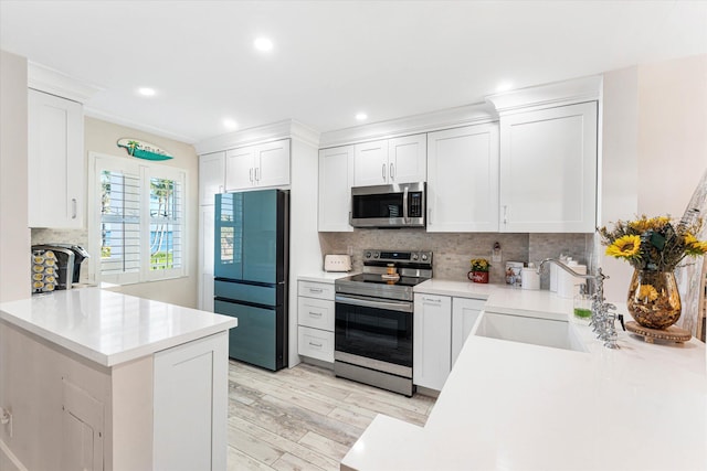 kitchen featuring kitchen peninsula, sink, white cabinetry, and stainless steel appliances