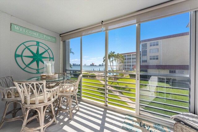 sunroom / solarium featuring a water view