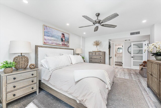 bedroom with ceiling fan, connected bathroom, and light hardwood / wood-style flooring