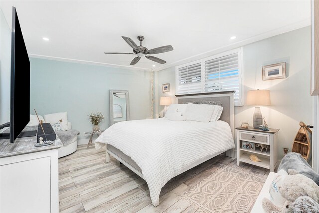 bedroom with ceiling fan, light wood-type flooring, and crown molding