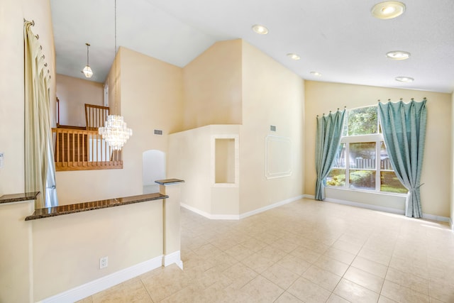 spare room featuring visible vents, vaulted ceiling, baseboards, and light tile patterned floors