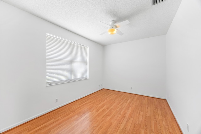 unfurnished room featuring a ceiling fan, baseboards, a textured ceiling, and light wood finished floors