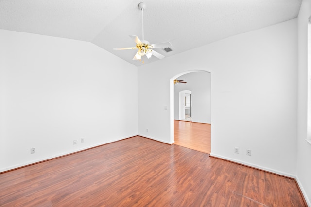 unfurnished room featuring visible vents, arched walkways, lofted ceiling, ceiling fan, and wood finished floors