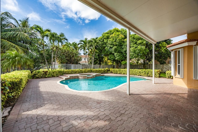 view of pool with a patio, a fenced backyard, and a pool with connected hot tub