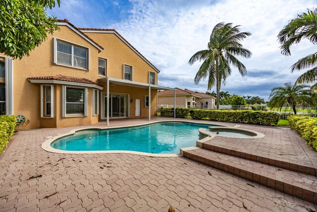 view of pool with an in ground hot tub, a patio, fence, and a fenced in pool